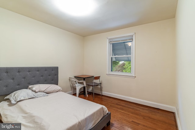 bedroom featuring wood finished floors and baseboards