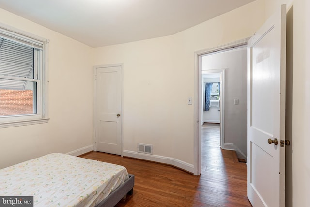 bedroom featuring wood finished floors and baseboards