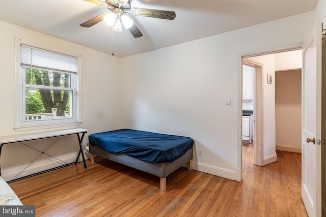 bedroom featuring light wood-style flooring, baseboards, and a ceiling fan