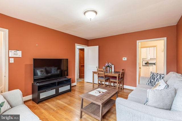living room with light wood-type flooring and baseboards