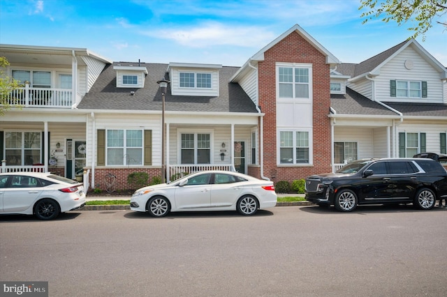 townhome / multi-family property featuring brick siding and a shingled roof