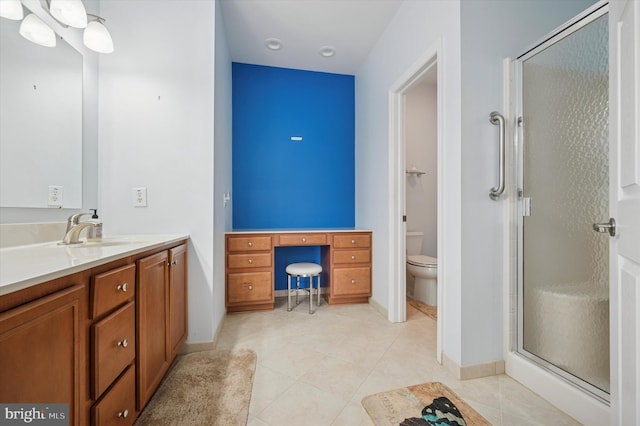 full bathroom featuring vanity, toilet, a stall shower, baseboards, and tile patterned flooring