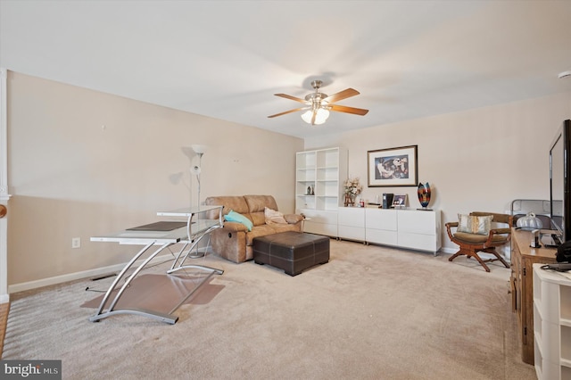 carpeted living room featuring a ceiling fan and baseboards
