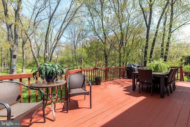 deck with outdoor dining area and area for grilling