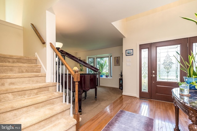 entryway featuring stairway, baseboards, and hardwood / wood-style flooring