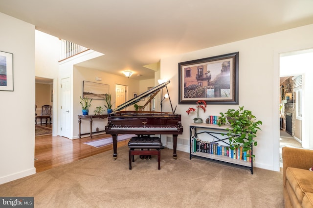 living area with baseboards, carpet flooring, and stairs