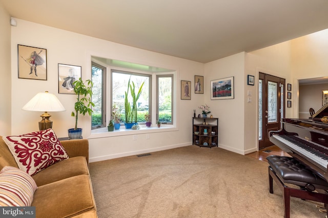 living area with baseboards, carpet, and visible vents