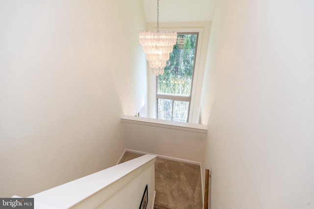 interior space featuring baseboards, carpet floors, and a notable chandelier