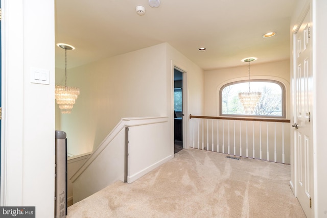corridor featuring visible vents, an upstairs landing, an inviting chandelier, carpet flooring, and recessed lighting
