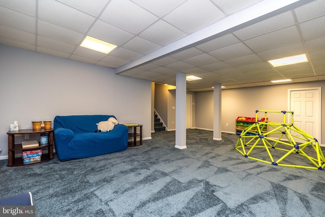 finished basement featuring carpet flooring, baseboards, a paneled ceiling, and stairs