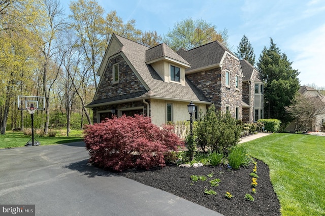 view of home's exterior with a yard, a shingled roof, stone siding, and stucco siding