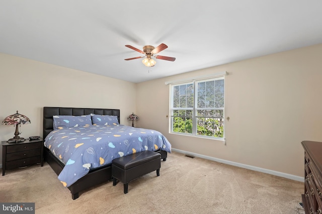 carpeted bedroom with visible vents, a ceiling fan, and baseboards