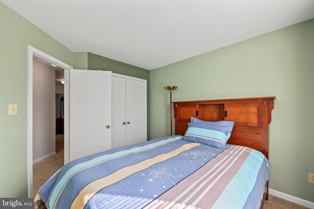 carpeted bedroom with baseboards and a closet