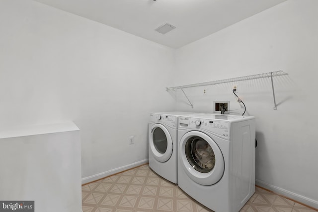 clothes washing area featuring separate washer and dryer, laundry area, and baseboards