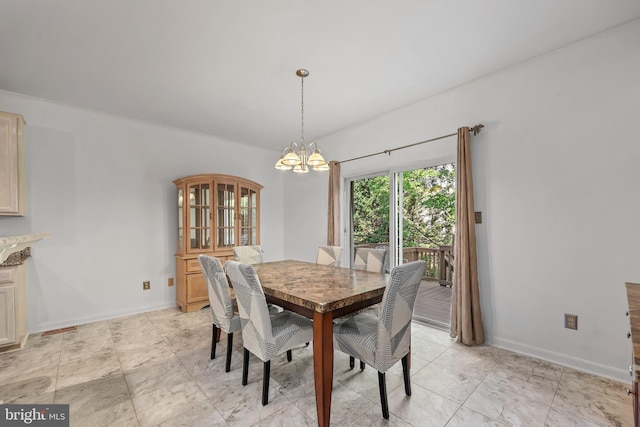 dining space featuring baseboards and a notable chandelier