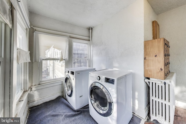 clothes washing area with laundry area, a textured ceiling, a textured wall, and radiator