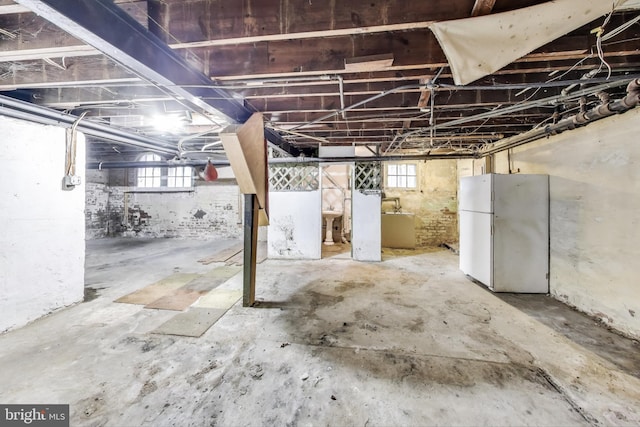 basement featuring freestanding refrigerator