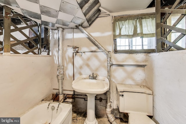 full bathroom with a sink, a bath, and toilet