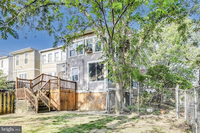 rear view of property featuring fence private yard, a wooden deck, and stairway