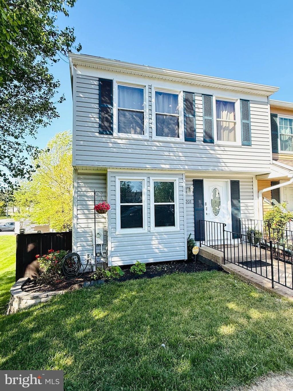 colonial inspired home with a front lawn and fence
