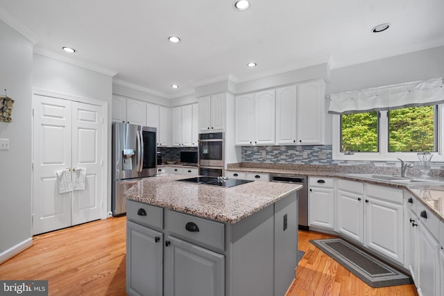 4209 Hardy Ridge Dr, Woodbridge, VA 22192 - kitchen with gray cabinets, a kitchen island, appliances with stainless steel finishes, a sink, and white cabinetry
