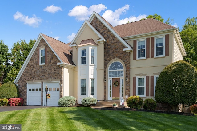4209 Hardy Ridge Dr, Woodbridge, VA 22192 - traditional-style house with stone siding, a garage, stucco siding, a front yard, and driveway