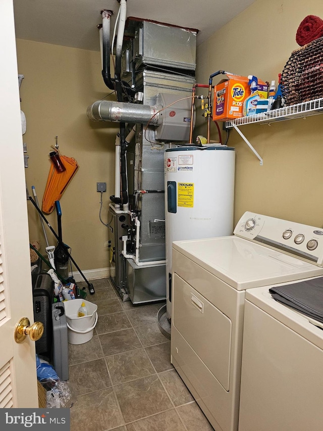 clothes washing area featuring electric water heater, laundry area, and washer and clothes dryer