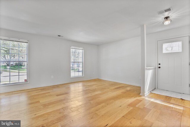 foyer with baseboards, visible vents, a wealth of natural light, and light wood-style floors