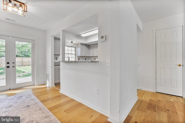 interior space featuring french doors, visible vents, a wealth of natural light, and light wood-style flooring