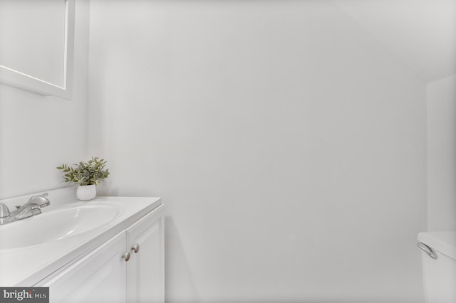 half bathroom with vanity and toilet
