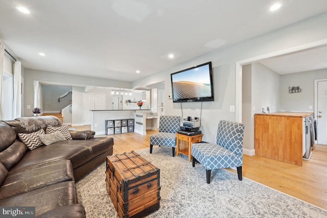 living area featuring light wood finished floors, stairway, baseboards, and recessed lighting