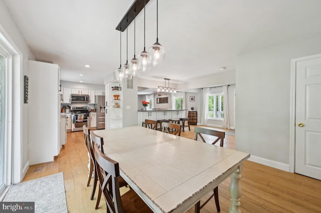 dining room featuring a chandelier, baseboards, light wood-type flooring, and recessed lighting