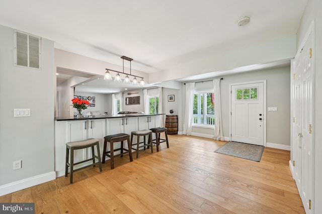 entrance foyer with light wood-style floors, visible vents, and baseboards