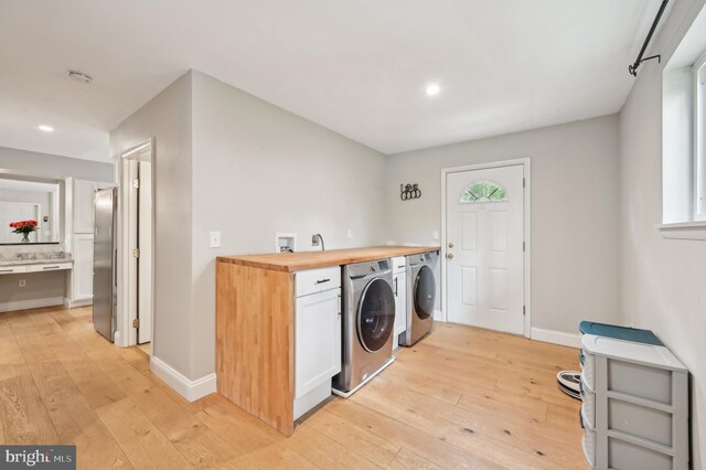 laundry area with baseboards, light wood finished floors, and recessed lighting