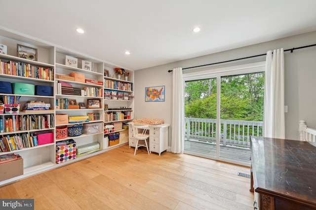 living area with recessed lighting, visible vents, and wood-type flooring