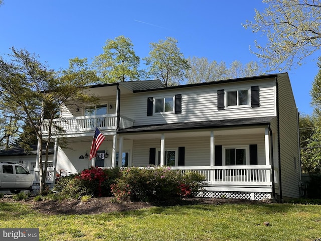 traditional home featuring covered porch and a front yard