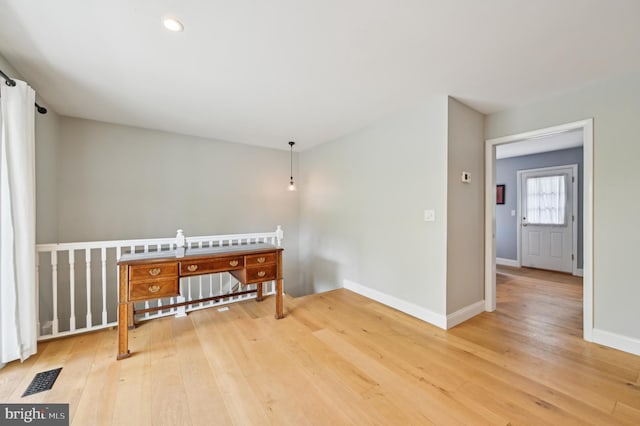 interior space featuring baseboards, visible vents, and light wood-style floors