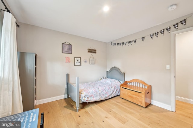 bedroom with wood finished floors and baseboards