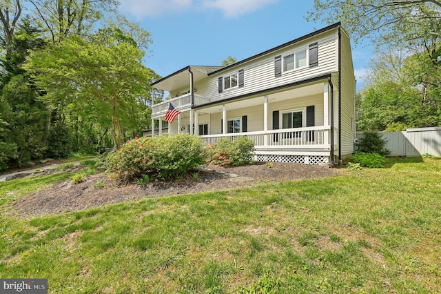 rear view of house with a yard, a porch, and fence