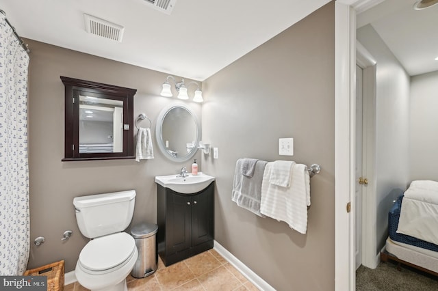 ensuite bathroom with toilet, baseboards, visible vents, tile patterned flooring, and vanity
