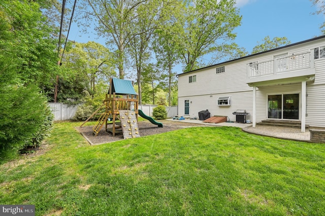 rear view of property featuring a balcony, a yard, fence, a patio area, and a playground