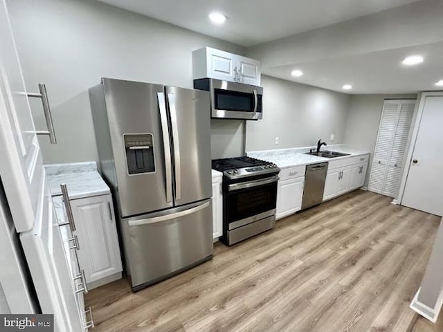 kitchen with light wood-style floors, light countertops, and appliances with stainless steel finishes