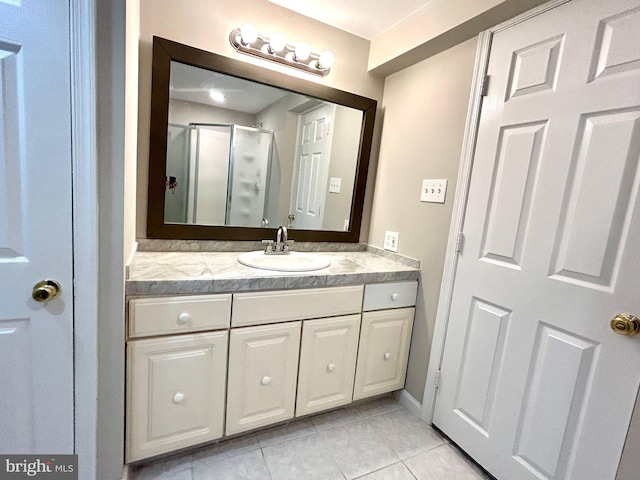 bathroom featuring a shower stall, tile patterned flooring, and vanity