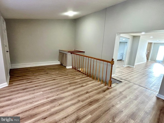 interior space with wood finished floors, an upstairs landing, and baseboards