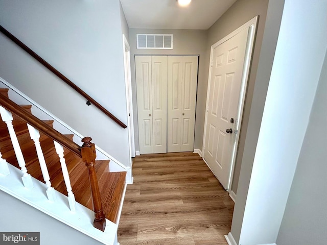 entrance foyer featuring stairway, light wood-style flooring, baseboards, and visible vents