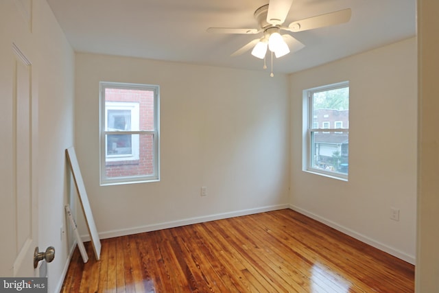 unfurnished room with a ceiling fan, baseboards, and light wood-style floors