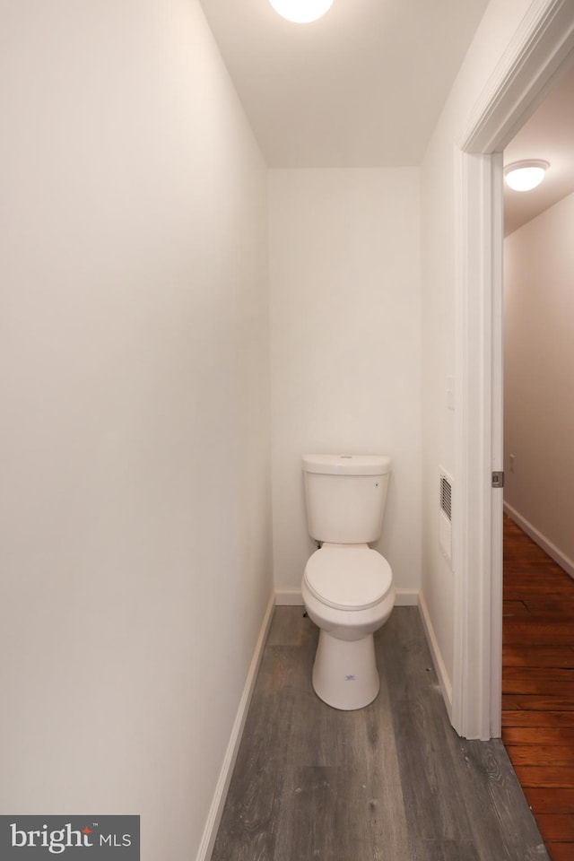 bathroom featuring baseboards, toilet, and wood finished floors