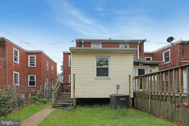 back of house featuring a lawn, fence, and cooling unit