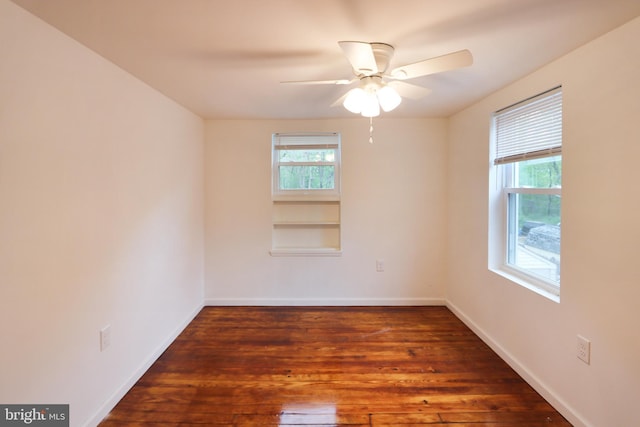 empty room with baseboards, plenty of natural light, a ceiling fan, and wood finished floors