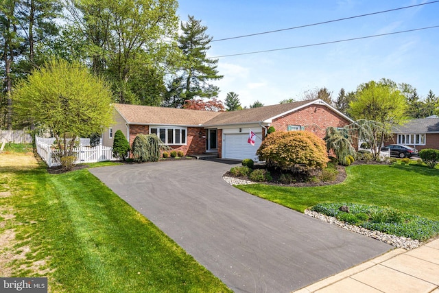 ranch-style home featuring aphalt driveway, a garage, brick siding, fence, and a front lawn